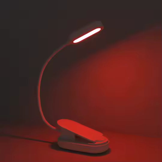 A compact red book light resting on a red surface