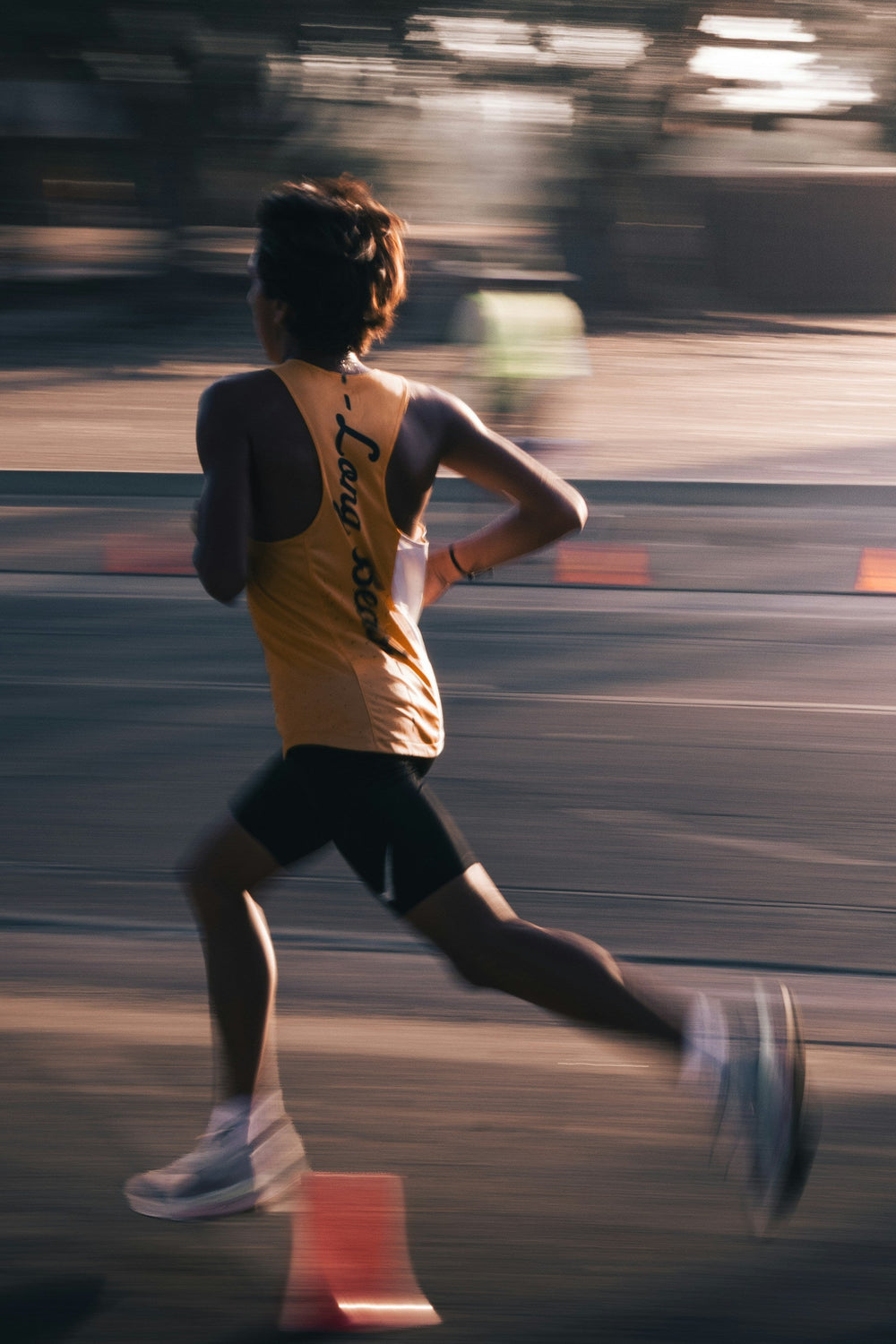 Runner mid-stride on a road, motion-blurred background