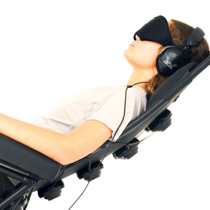 A client reclined in the Shiftwave Pro chair with eye mask and headphones